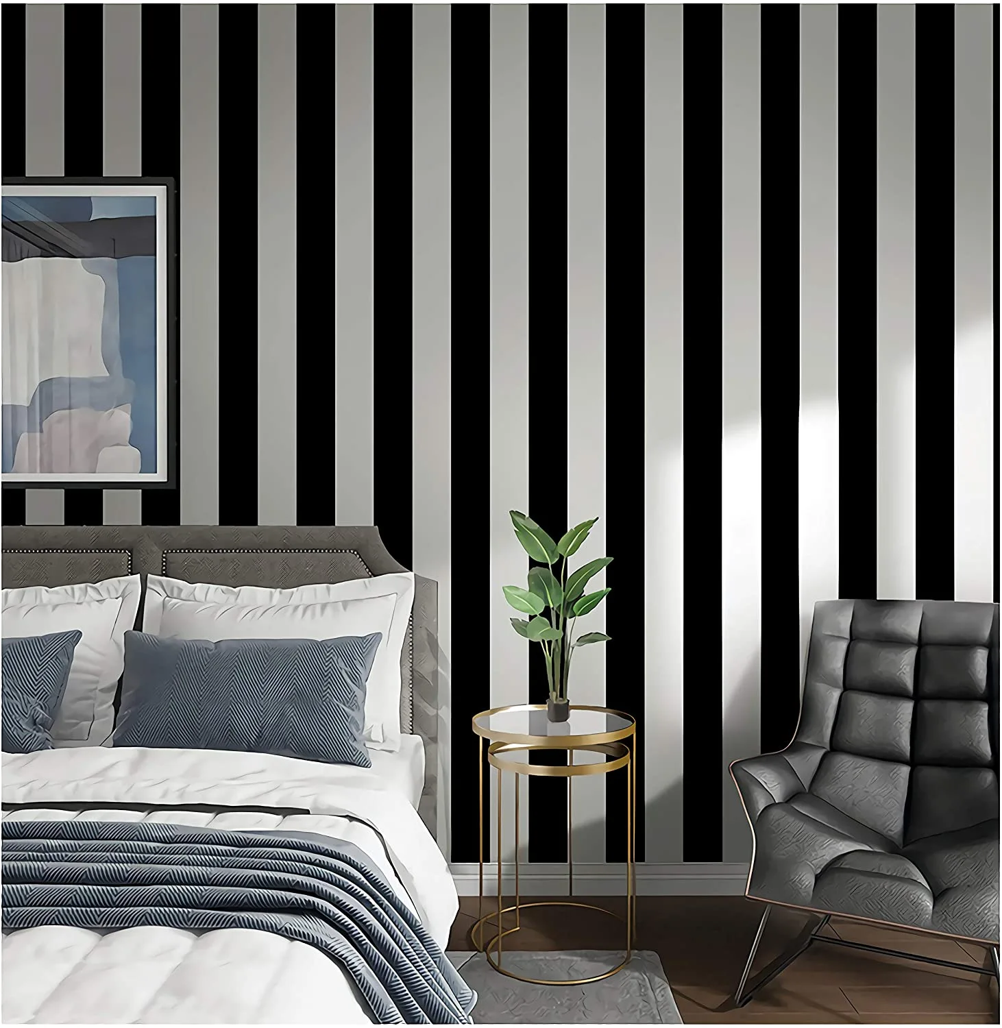 A modern bedroom with a grey tufted headboard and a dark grey armchair set against bold black and white vertical striped wallpaper.