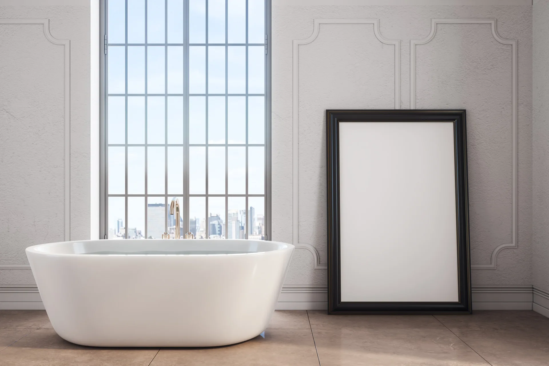 A sleek white freestanding bathtub is set on tan floor tiles next to a large window and a black picture frame leaning against grey paneled walls.