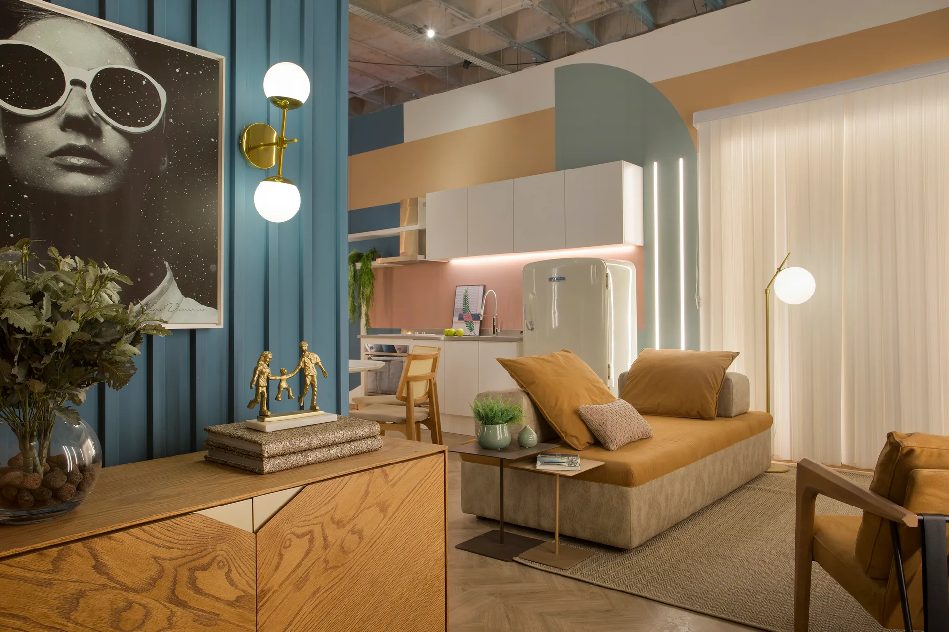 A living area and kitchen featuring a blue slatted wall panel, a tan sofa, geometric wall paint, and a retro white refrigerator.