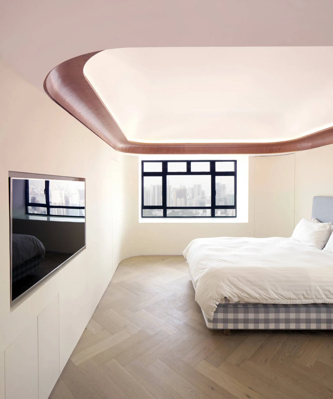 A minimalist bedroom featuring a curved recessed ceiling with wood trim, a bed with white linens, herringbone wood flooring, and a large window.