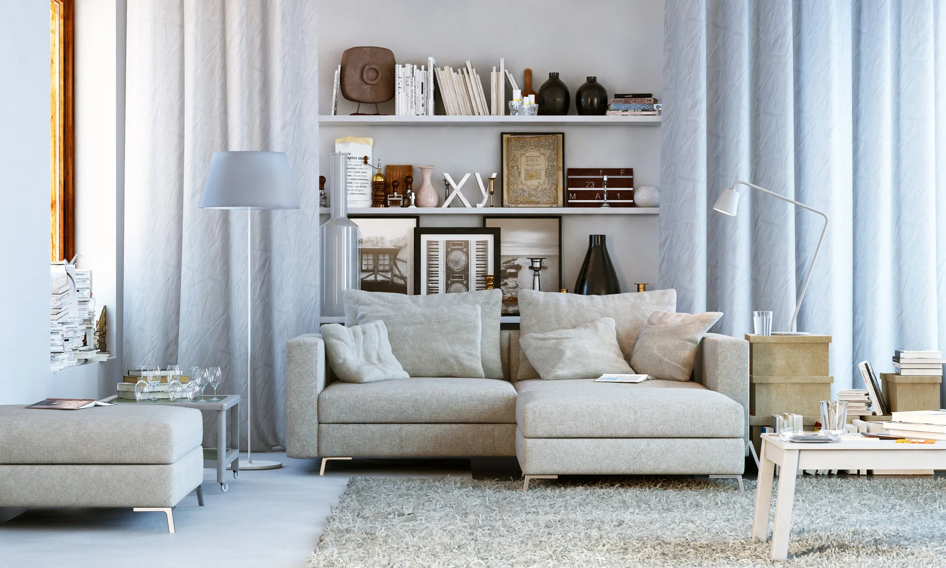A modern living room featuring a light grey sectional sofa in front of three white wall shelves filled with books and decorative art.