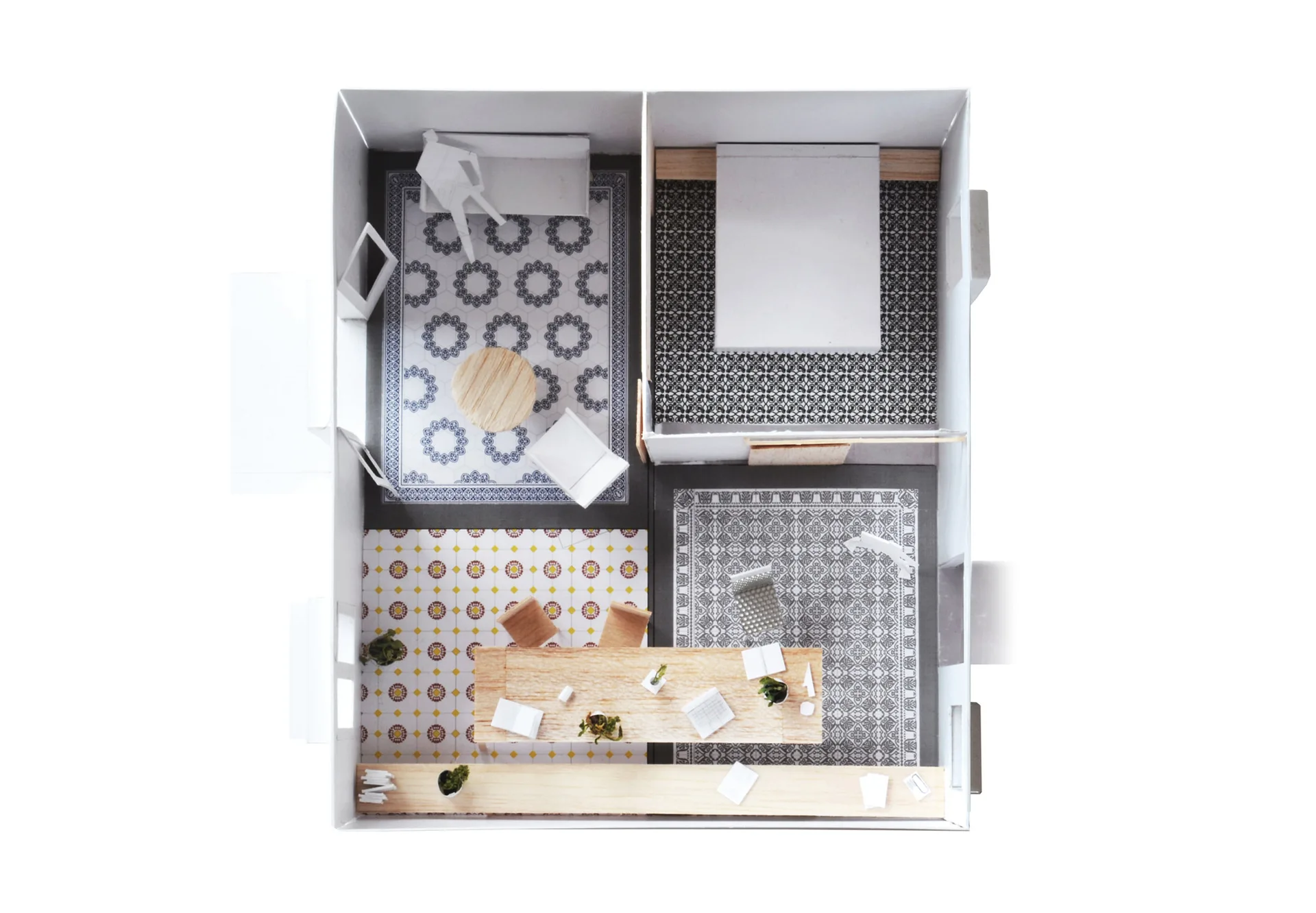 A top-down view of an architectural scale model featuring four rooms with different patterned floor tiles and miniature wood furniture.
