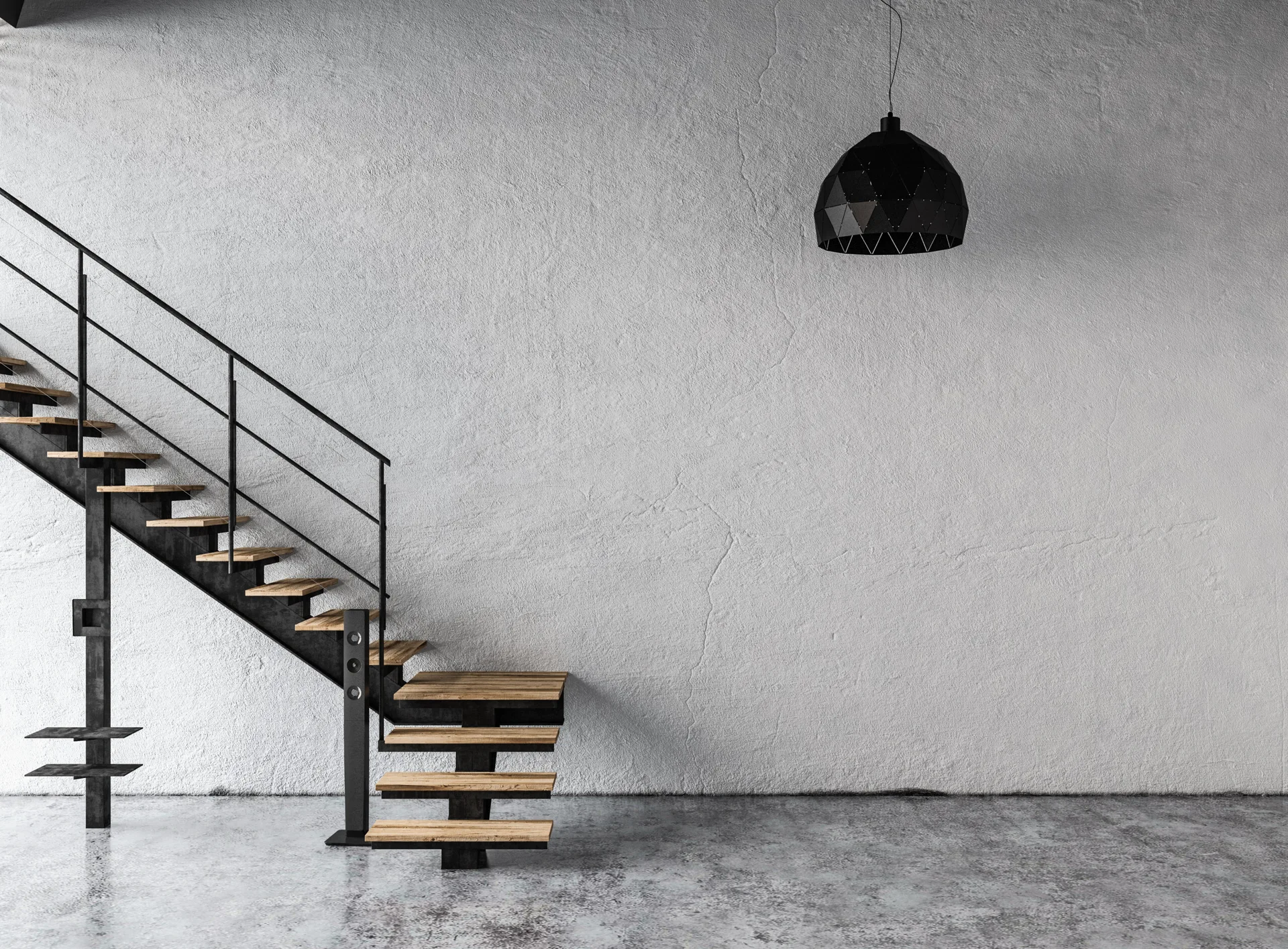 An industrial black metal staircase with wooden steps stands against a rough grey plaster wall on a polished concrete floor under a black pendant light.
