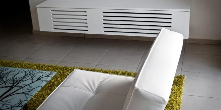 A modern white armchair sits beside a tree-patterned glass coffee table on a lime green shag rug, with a floating slatted console mounted on the wall.