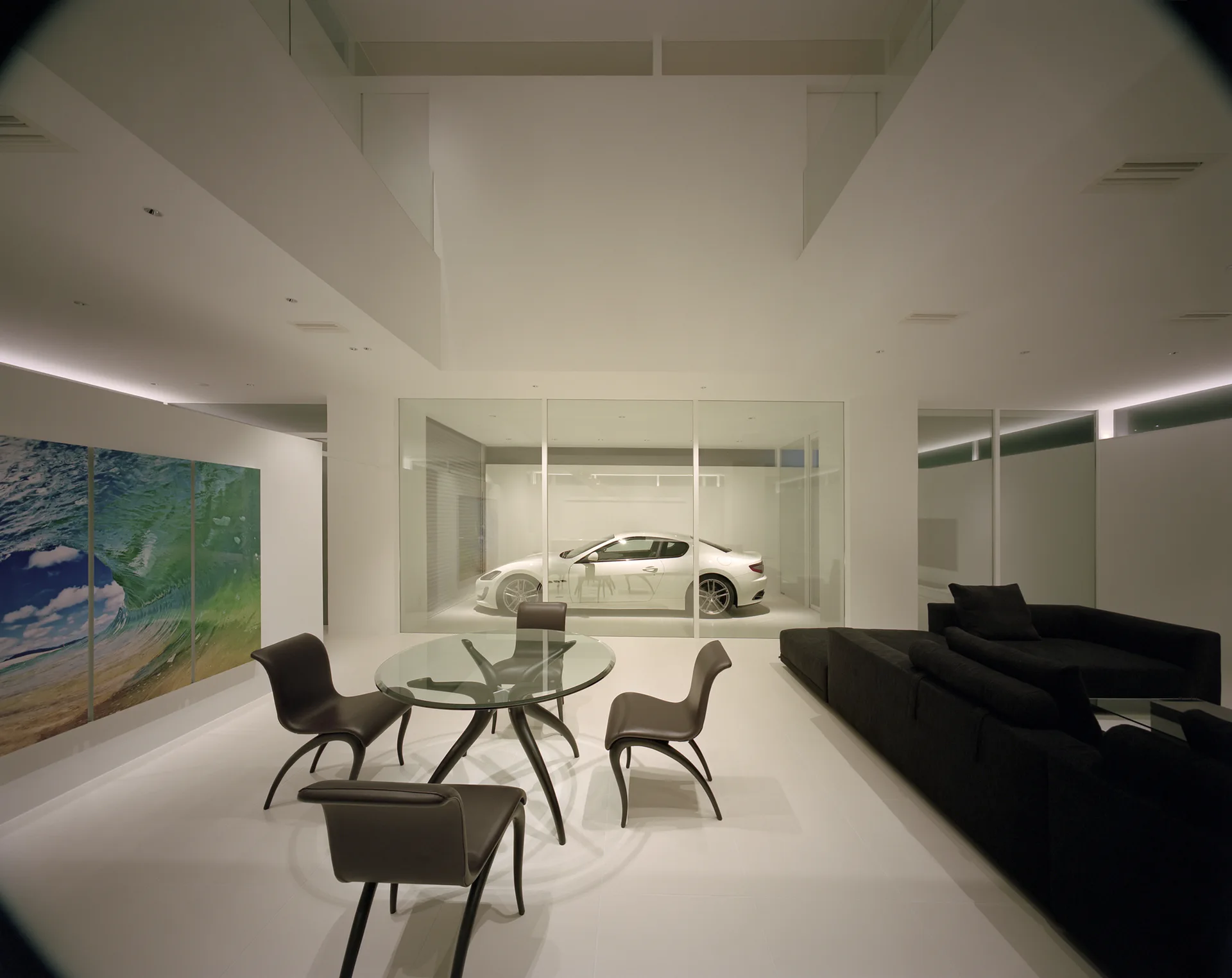 A minimalist open-plan living and dining room with white tile flooring features a glass partition showcasing a white car.