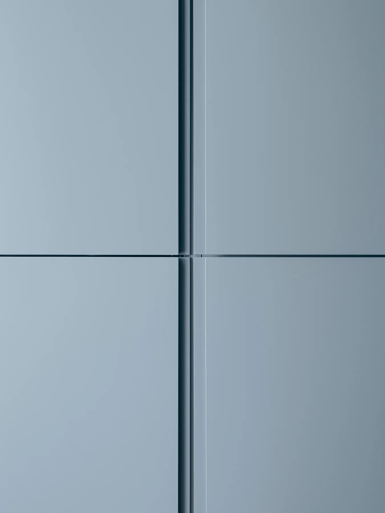 Four matte blue-grey flat-panel cabinet doors meeting at a clean vertical and horizontal intersection.
