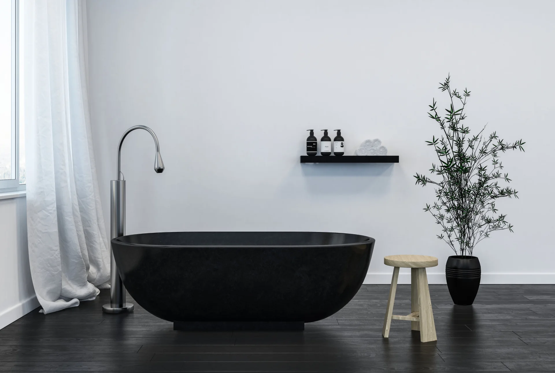 A minimalist bathroom features a black freestanding bathtub on dark wood floors, accompanied by a light wood stool and a tall potted plant.