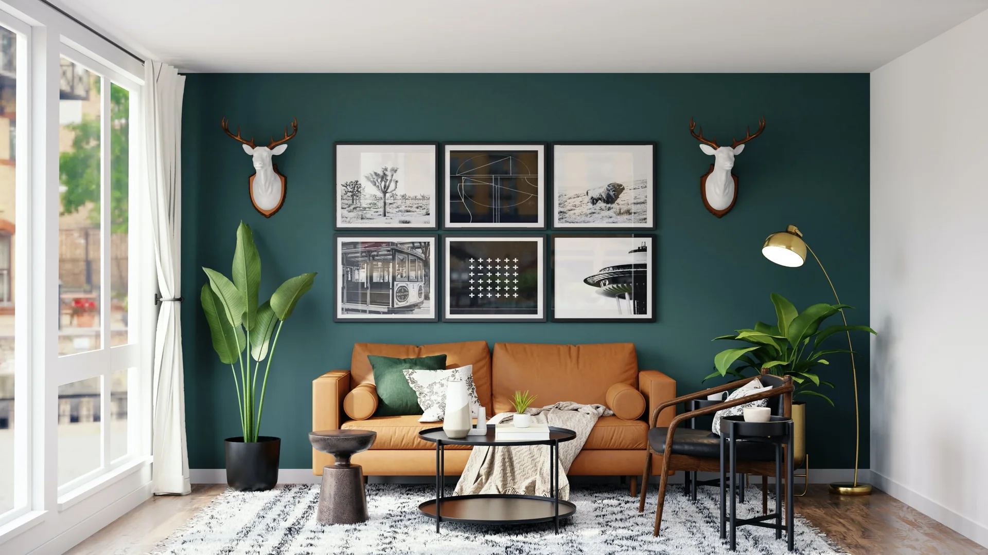 A modern living room features a tan leather sofa set against a deep teal wall decorated with six framed prints and two white deer head sculptures.