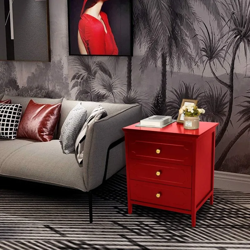 A bright red three-drawer nightstand sits next to a grey upholstered sofa against a monochrome palm tree wallpaper backdrop.