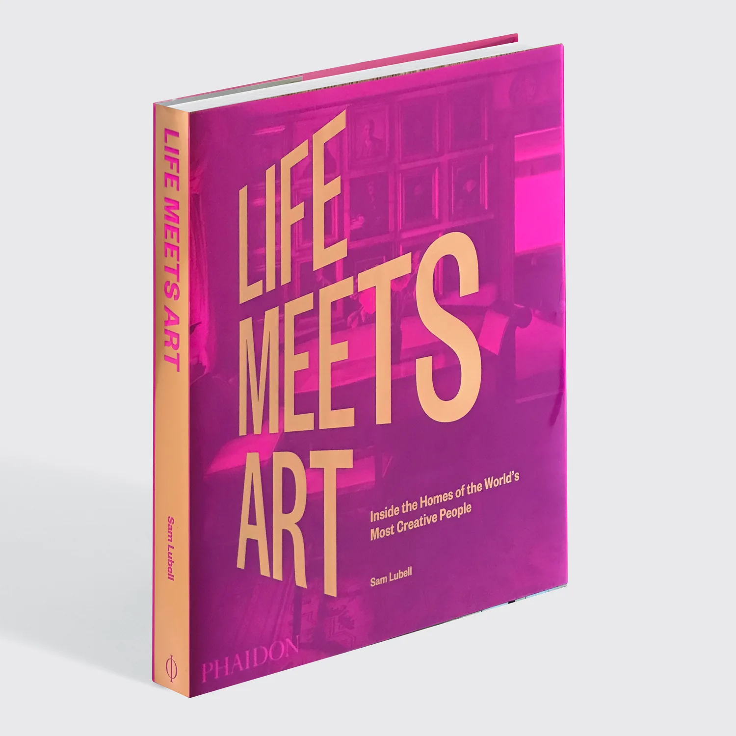A studio shot of the hardcover book Life Meets Art by Sam Lubell, featuring a glossy magenta cover with large orange typography.