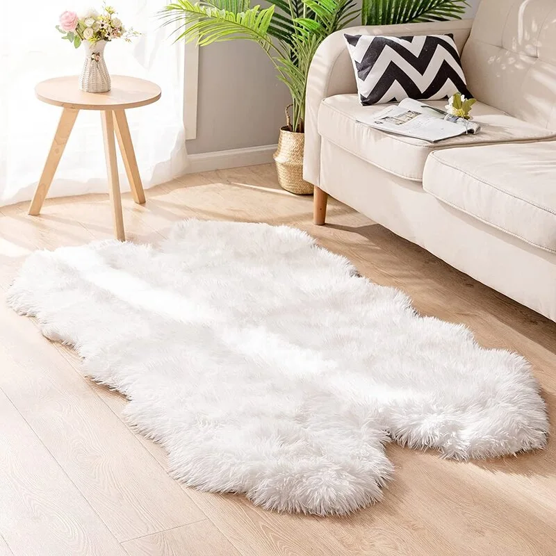 A light grey living room featuring a plush white faux fur rug on light wood floors beside a beige fabric sofa and a round wooden side table.