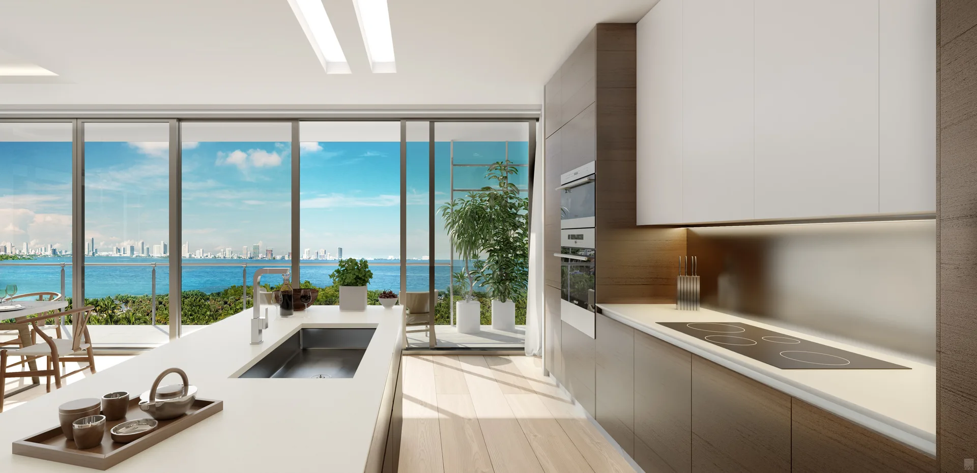 A minimalist kitchen features a white island with a sink, wood and white cabinets, and large glass doors opening to an ocean view.