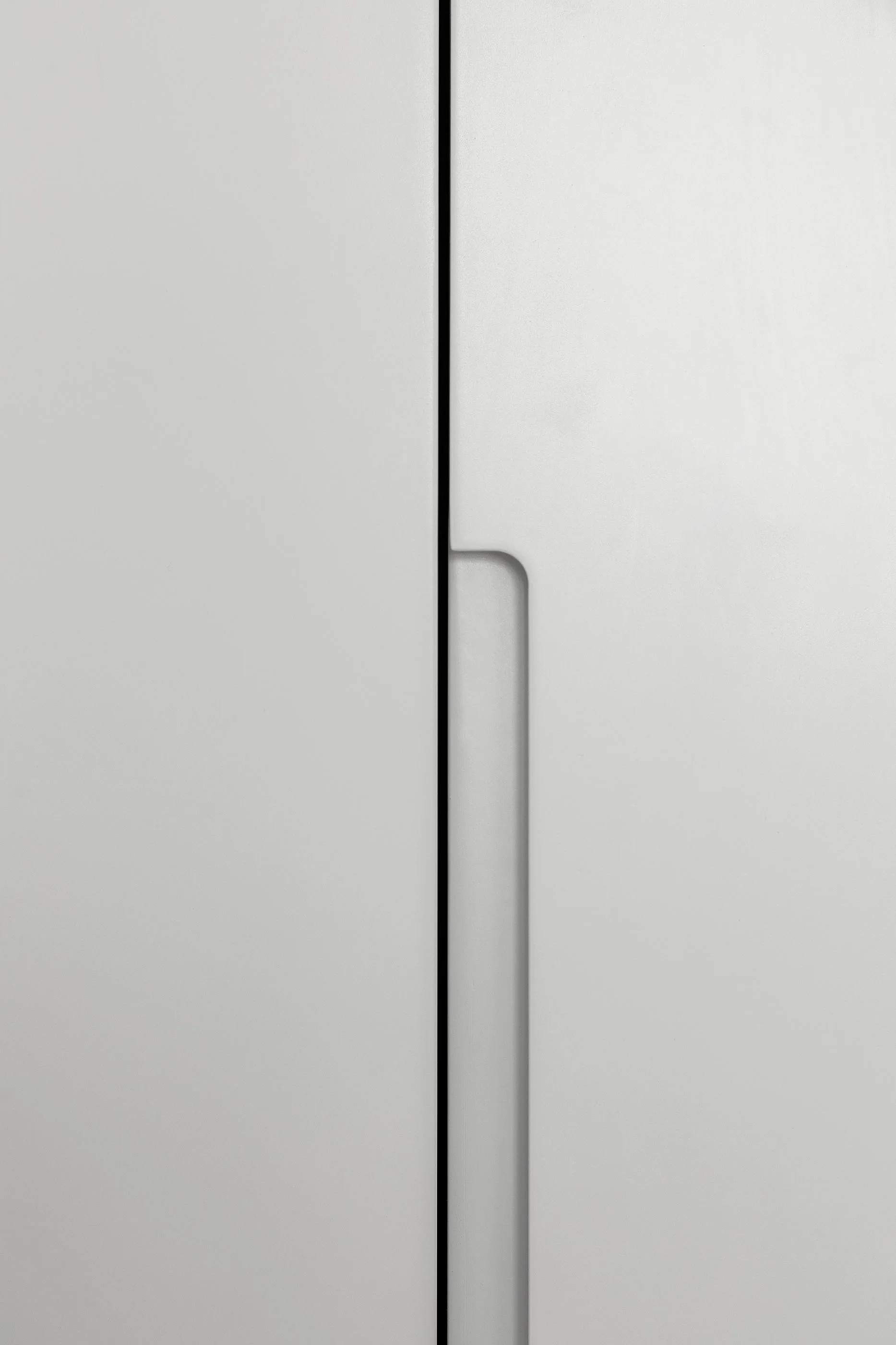 A close-up view of two light grey matte cabinet doors featuring a vertical integrated recessed handle detail along the center seam.