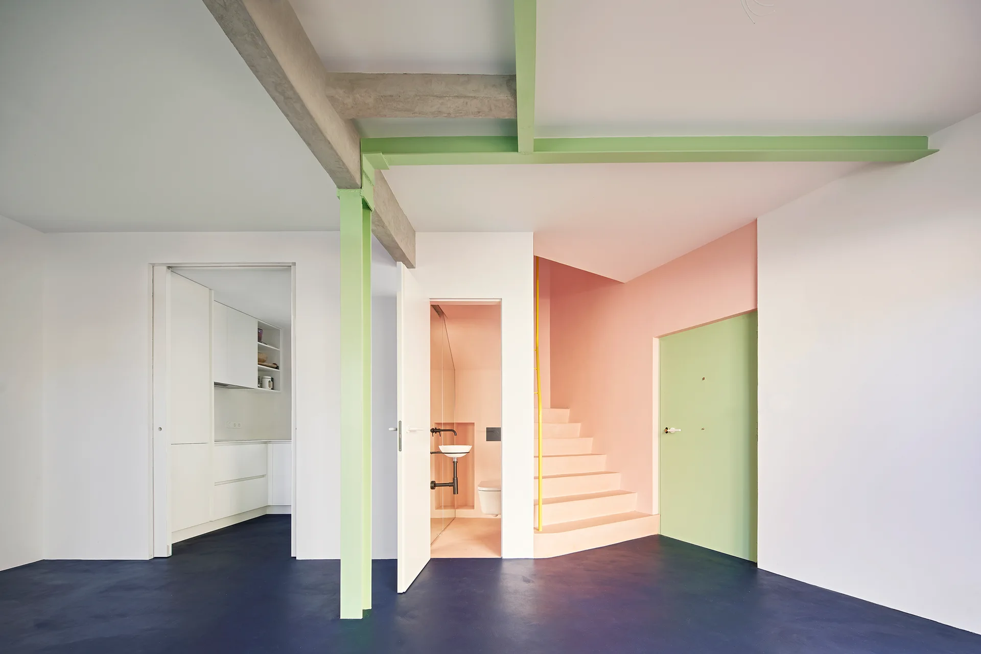 A minimalist modern entryway features a navy blue floor, a pastel pink staircase, and lime green painted structural beams.