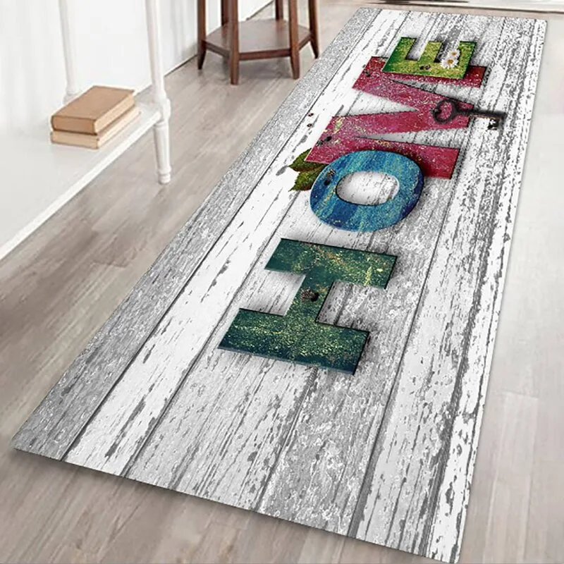 A long rectangular runner rug with a distressed white wood plank design and multicolored letters spelling HOME lies on a light wood floor.