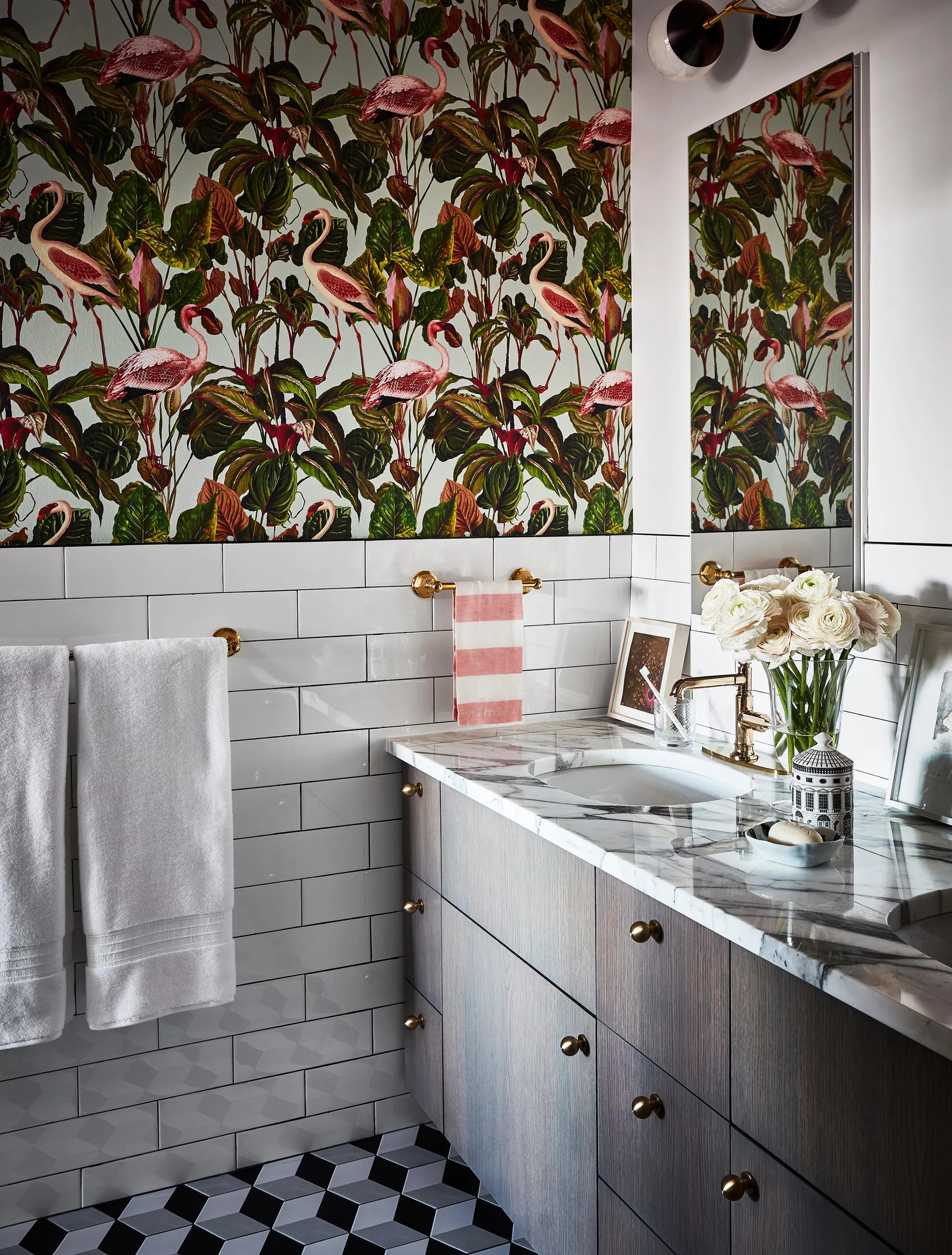 A bathroom featuring a wood vanity with a marble countertop, white subway tile walls, and green botanical flamingo wallpaper.