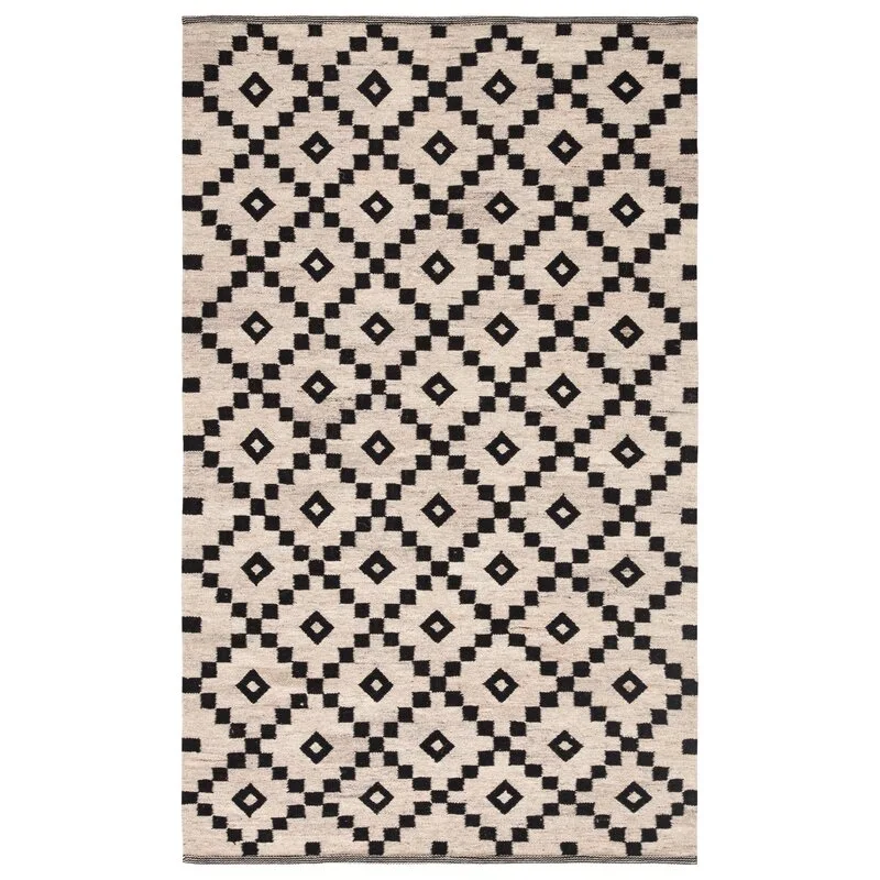 A rectangular woven area rug features a high contrast black diamond geometric pattern over a neutral cream colored background.
