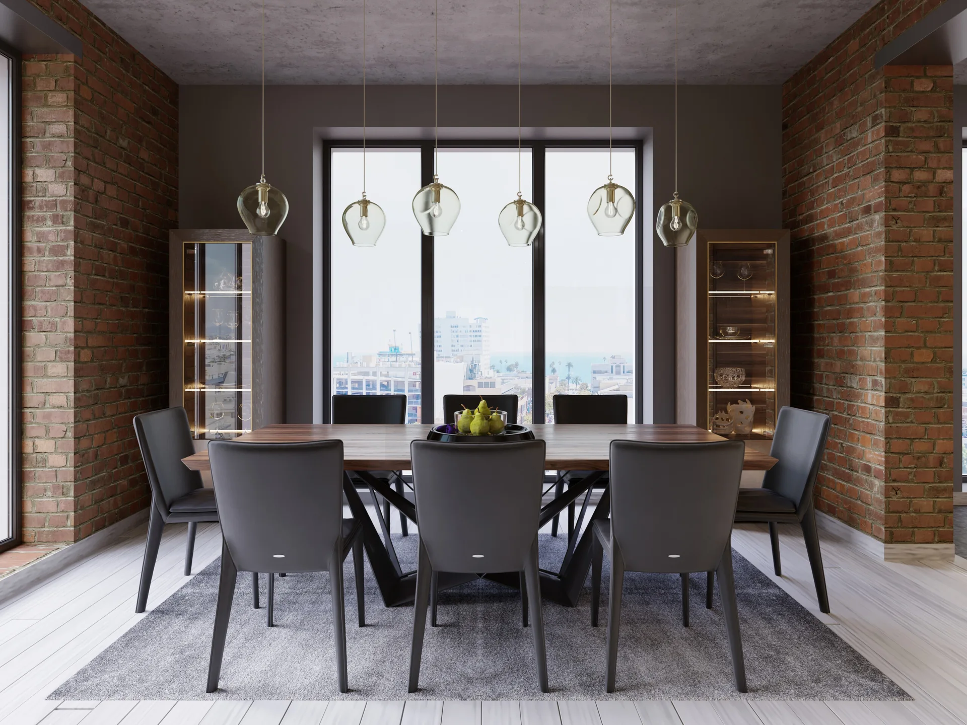 A wooden dining table with six dark grey chairs sits beneath glass pendant lights between exposed red brick walls.
