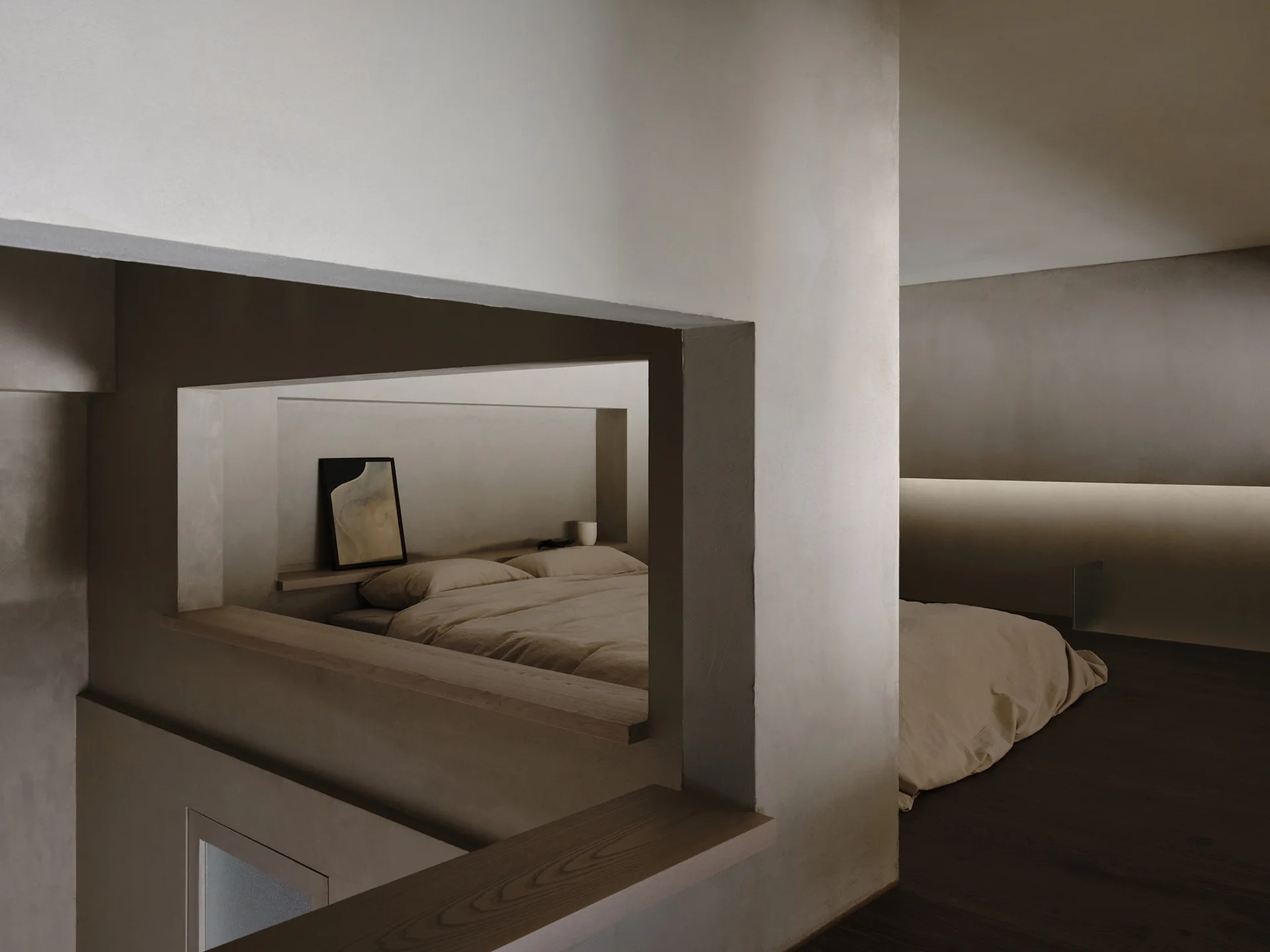 A minimalist bedroom featuring a bed nestled in a plaster-finish alcove with a built-in wooden shelf and soft ambient lighting.