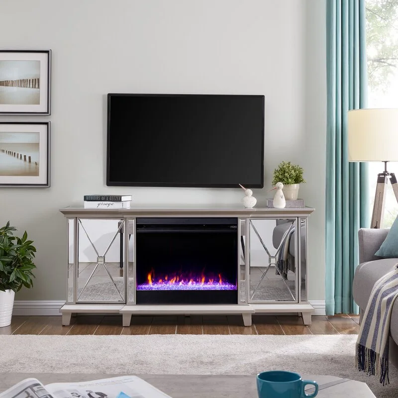 A mirrored electric fireplace console with geometric details sits beneath a wall-mounted TV in a light grey living room.