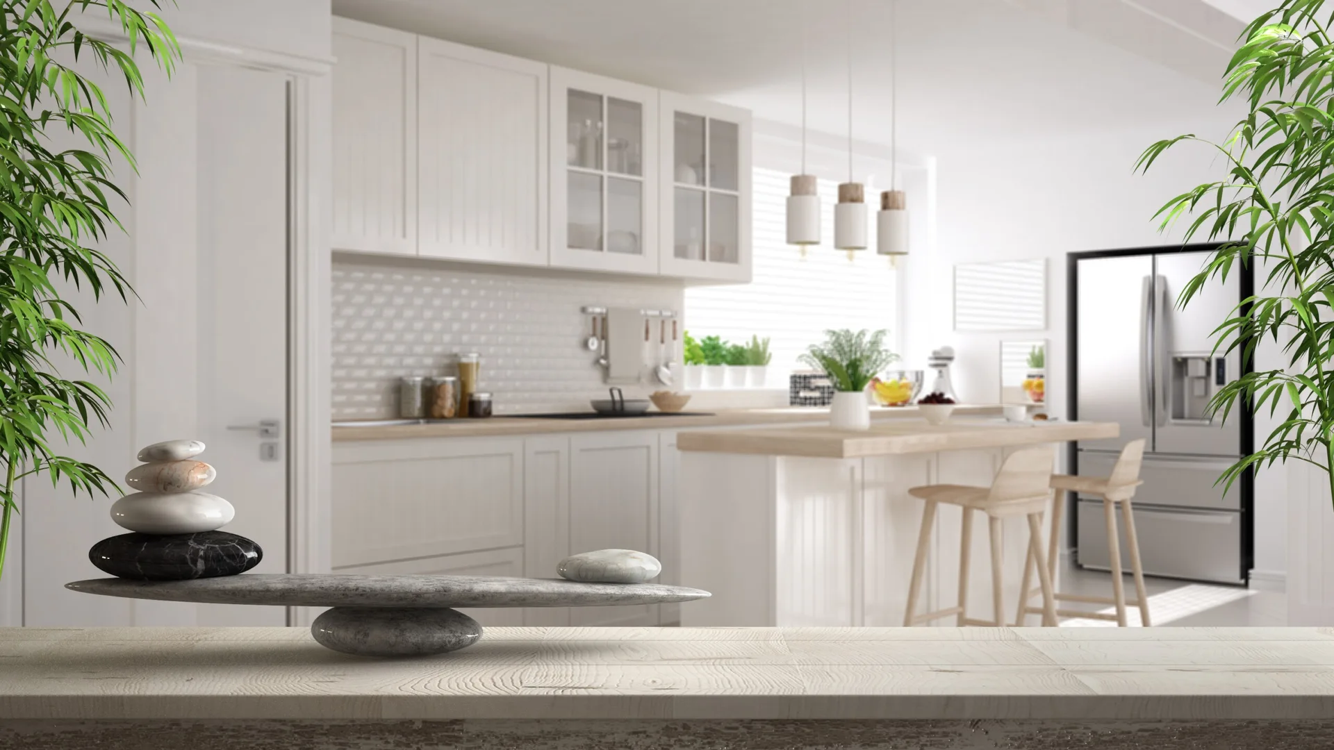 A stone balancing sculpture sits on a wooden foreground surface, overlooking a bright white kitchen with a wooden island and bar stools.