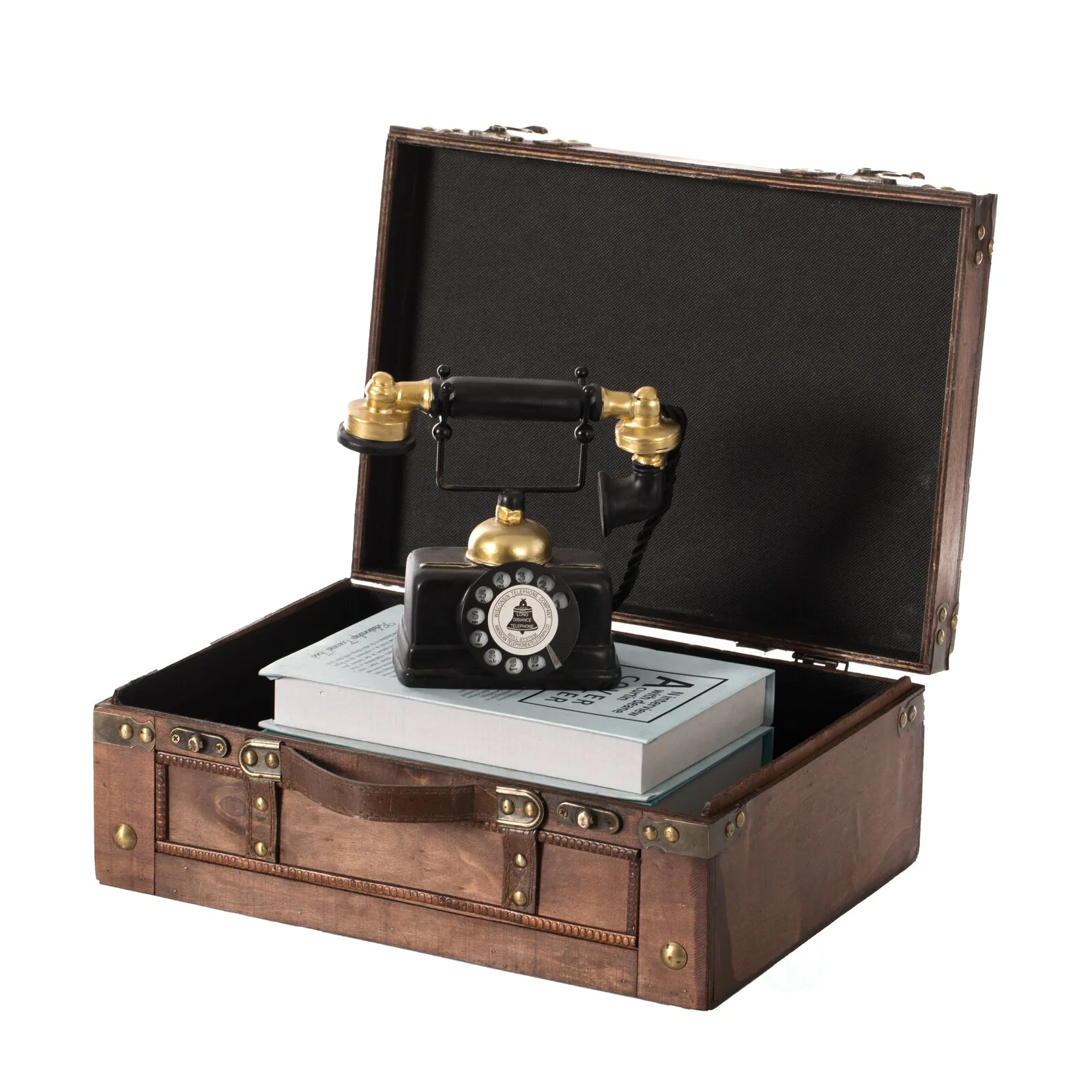 A vintage black and gold rotary telephone rests on stacked books inside an open brown wooden suitcase.
