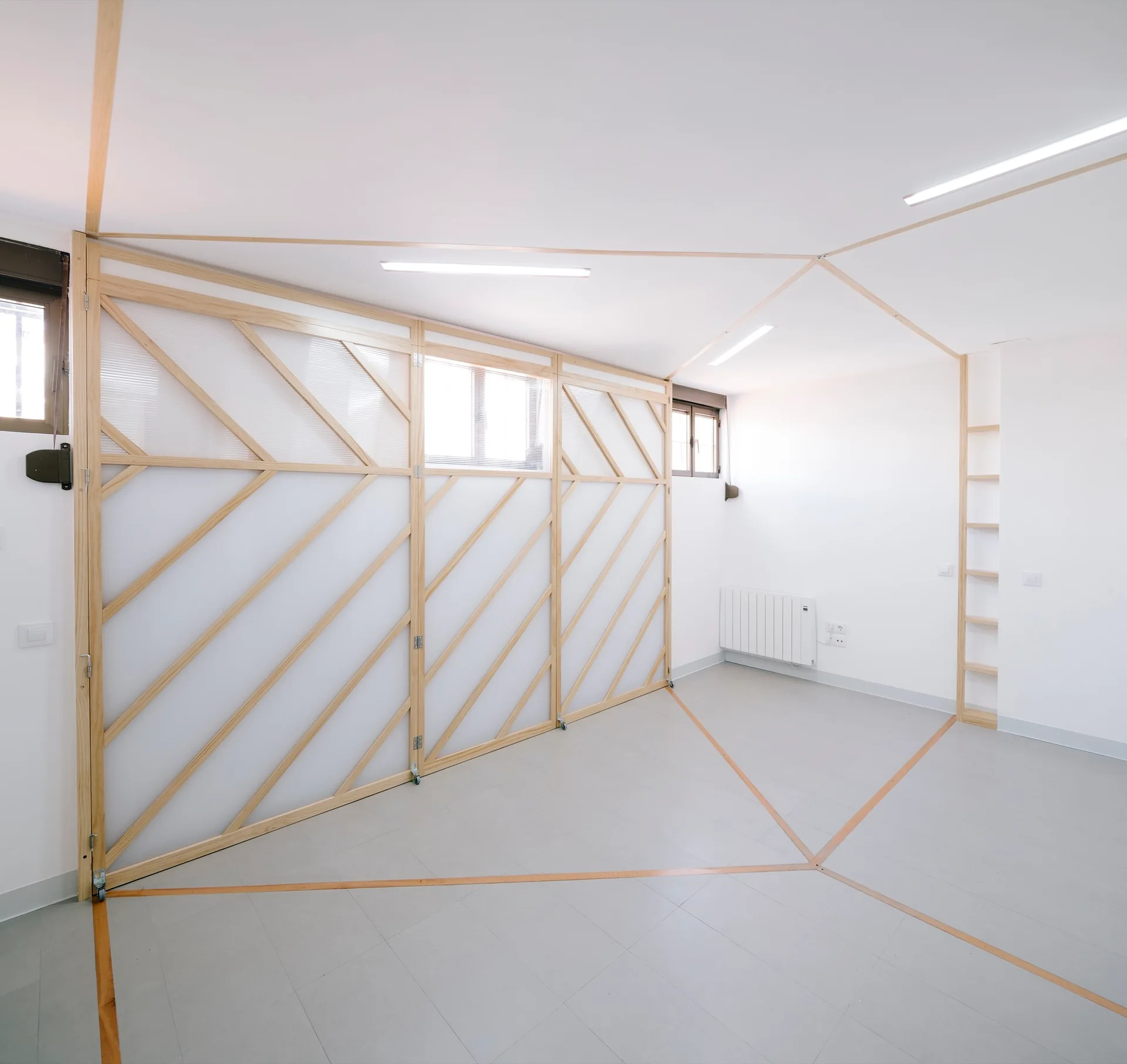 A minimalist white room featuring translucent sliding partition screens with light wood frames and geometric wood inlays on the floor and ceiling.