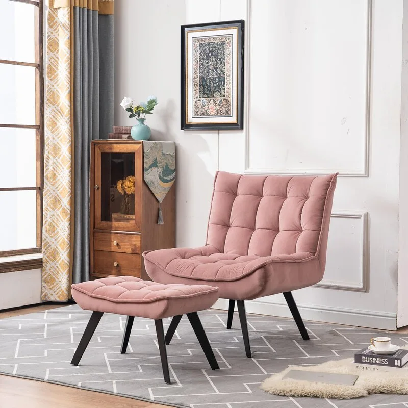 A pink tufted velvet armchair and matching ottoman rest on a grey geometric rug against a white wall with classic panel molding.