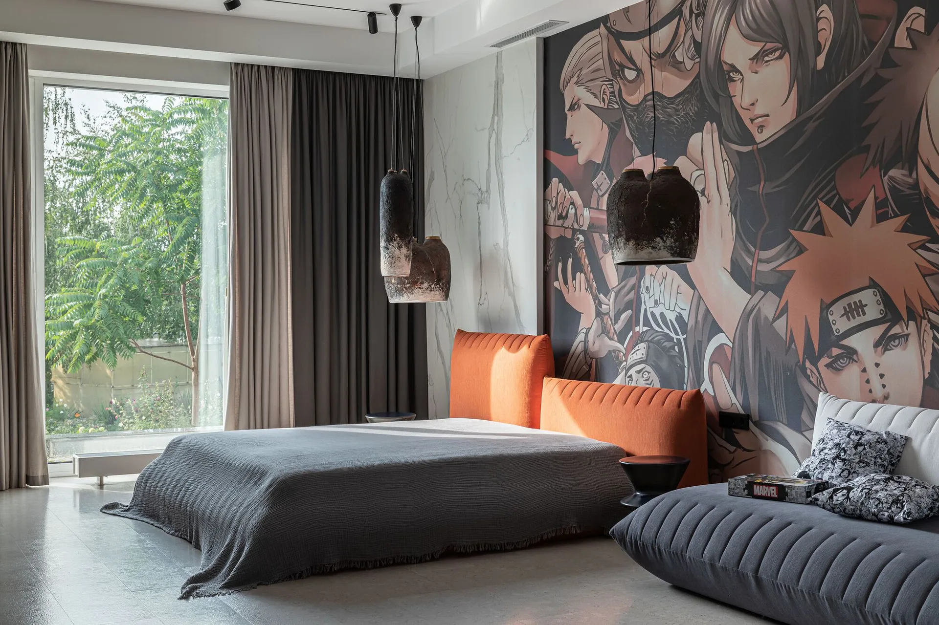 A modern bedroom featuring a large anime-style wall mural behind a low gray bed with a bold orange upholstered headboard and hanging pendant lights.