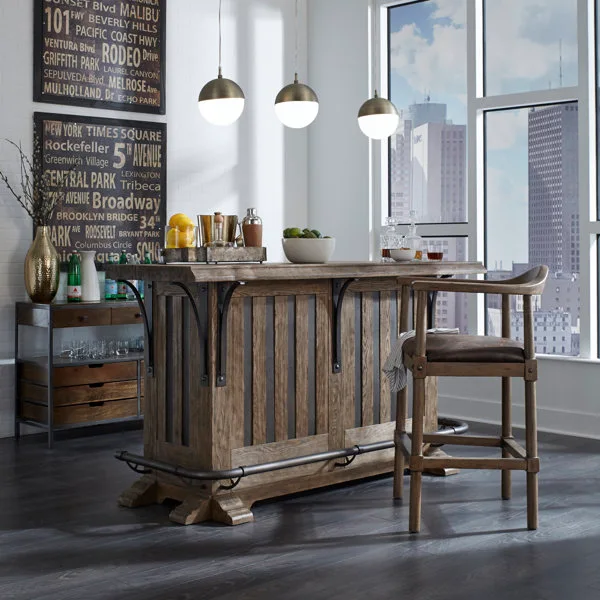 A rustic wood home bar counter with metal brackets features a matching bar stool, three brass globe pendant lights, and a city view window.