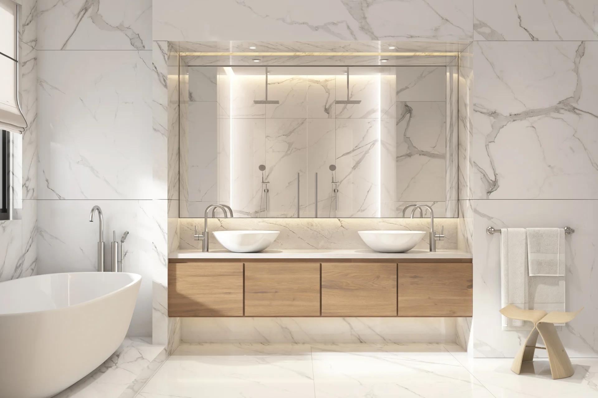 A modern bathroom features a floating wood vanity with double vessel sinks, a large back-lit mirror, and veined white marble walls.