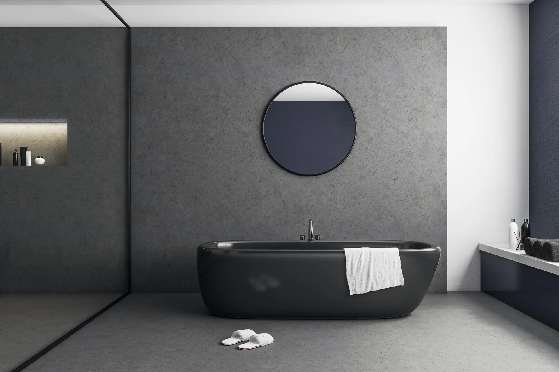 A minimalist bathroom features a freestanding black bathtub set against a textured grey wall with a circular mirror.