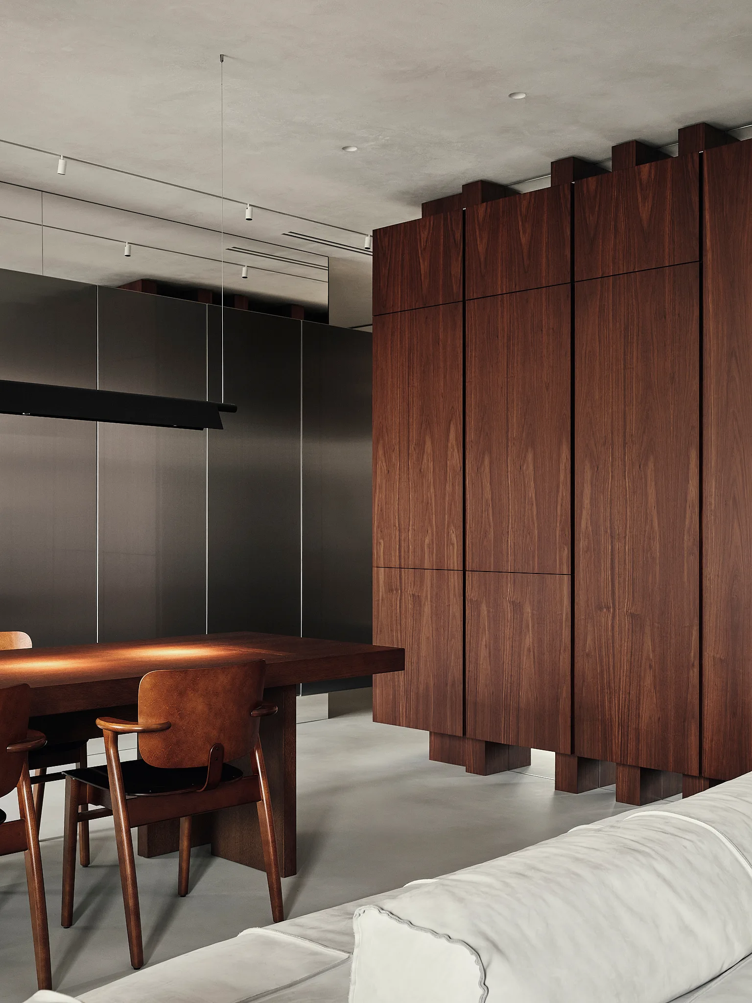 A modern dining area featuring a large walnut storage cabinet, a dark wood dining table with chairs, and concrete flooring.