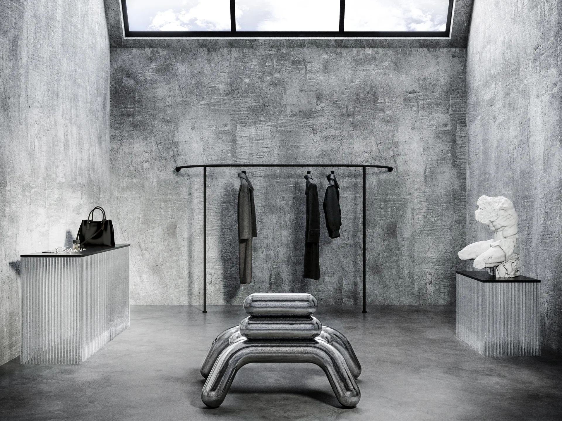 A minimalist gray room with raw concrete walls features a curved black clothing rack, fluted pedestals, and a sculptural metallic chrome stool.
