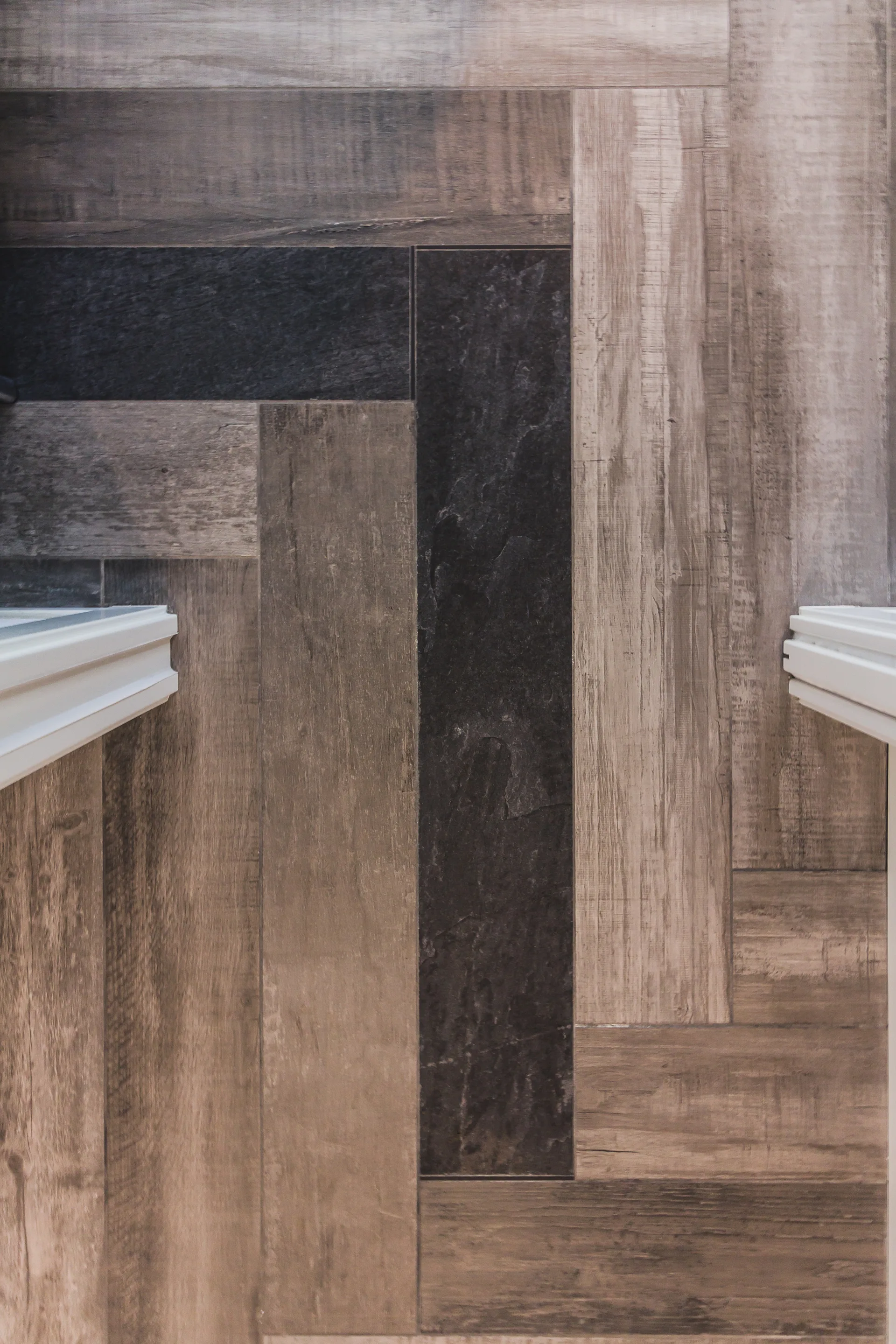 Vertical wood-look wall planks in mixed shades of brown, grey, and black are flanked by clean white trim on both sides.