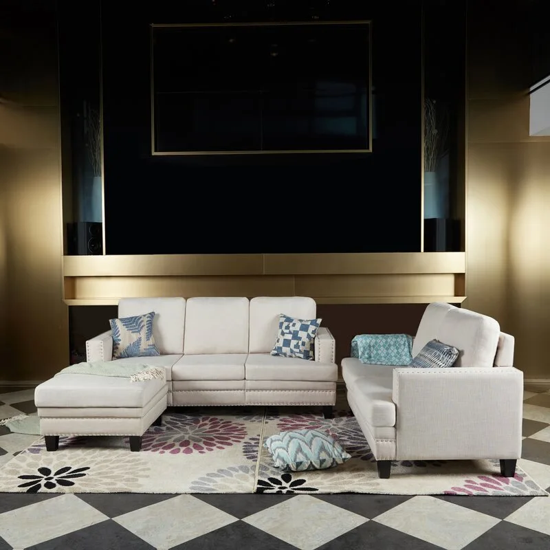 Cream fabric sofa and loveseat set arranged on a floral area rug over a black and white checkerboard tile floor.