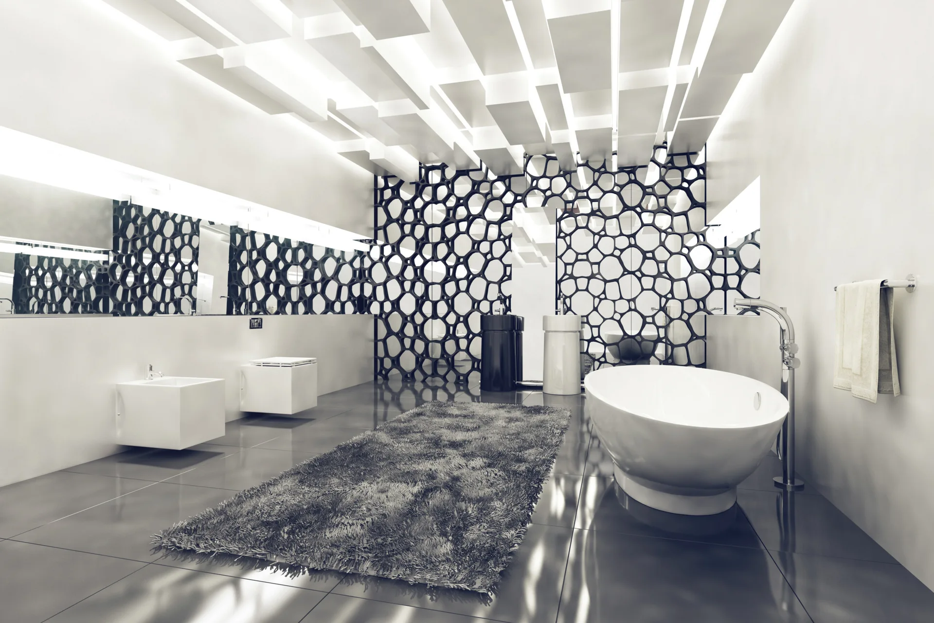 A modern bathroom features a freestanding white bathtub, a textured grey rug, black and white pedestal sinks, and a black geometric wall screen.