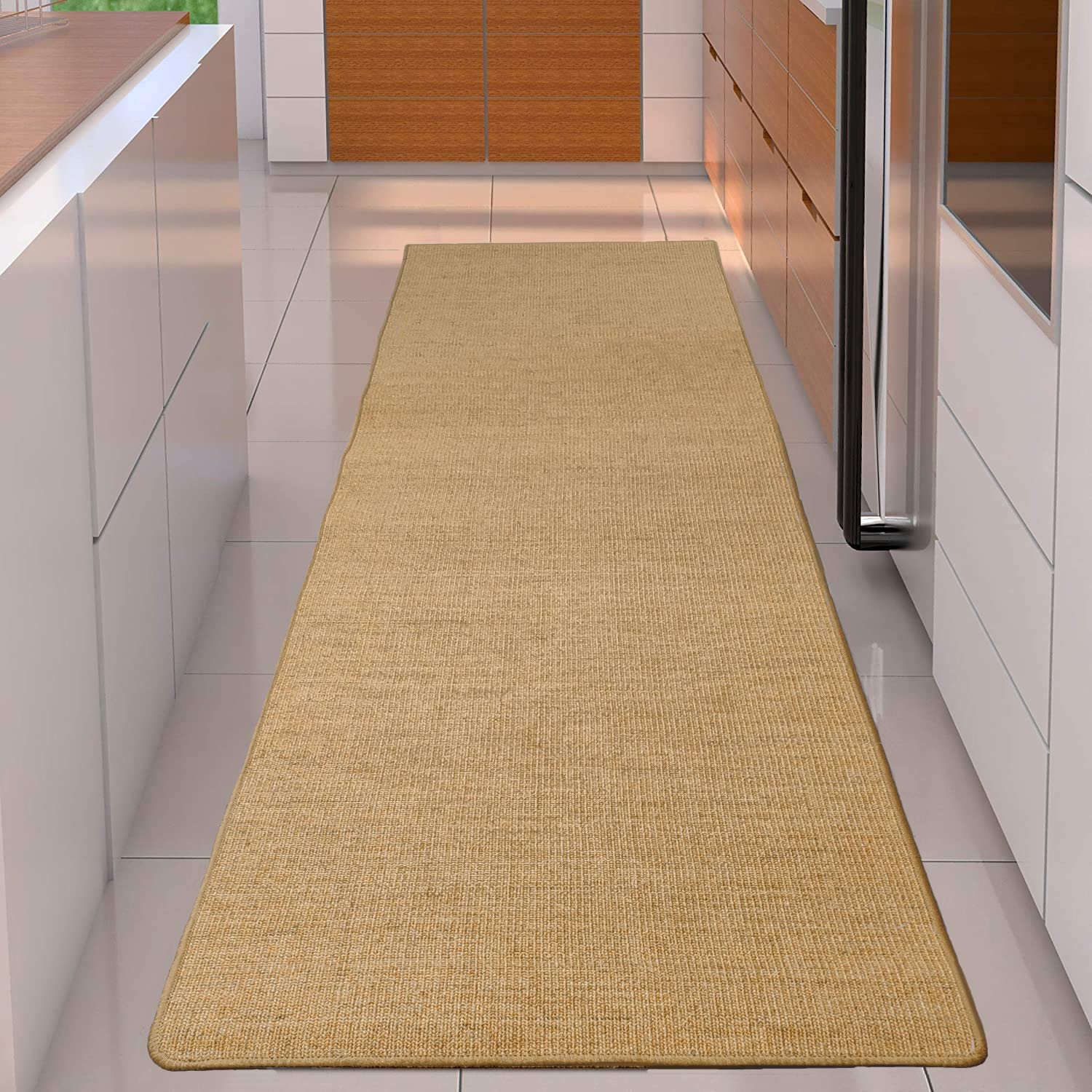 A long beige woven runner rug sits on white tile flooring in a modern galley kitchen with white and wood cabinetry.
