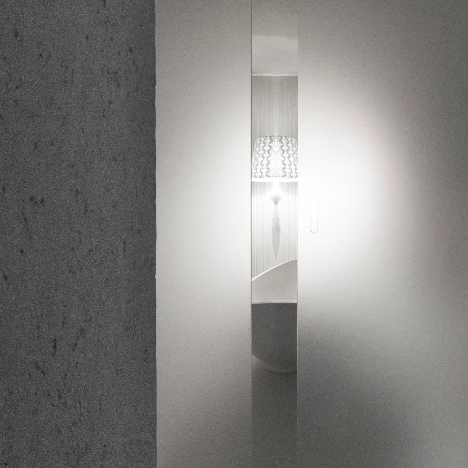 A narrow vertical gap between smooth white door panels reveals a softly lit textured table lamp and curved white furniture in a minimalist interior.