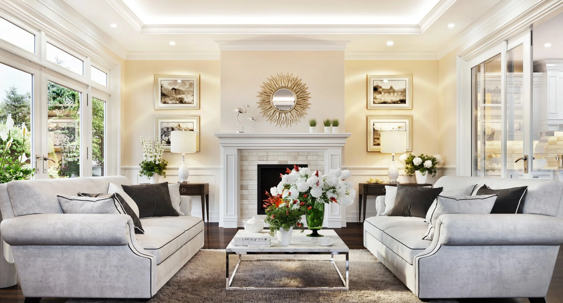 A symmetrical living room featuring two grey sofas facing each other, a central white fireplace with a sunburst mirror, and dark hardwood floors.