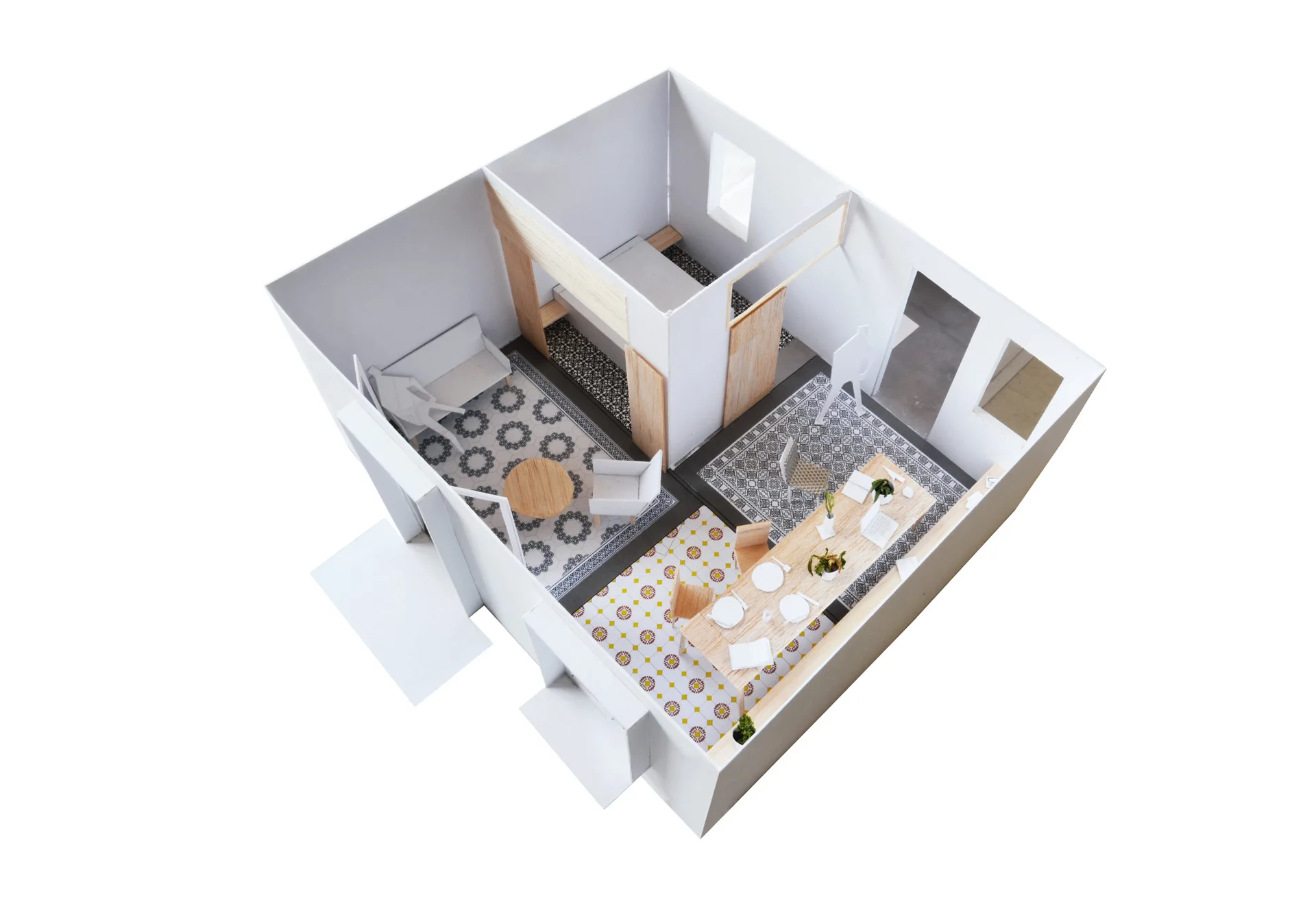 An architectural scale model of a modern apartment interior with white walls, light wood furniture, and varied geometric patterned floor tiles.