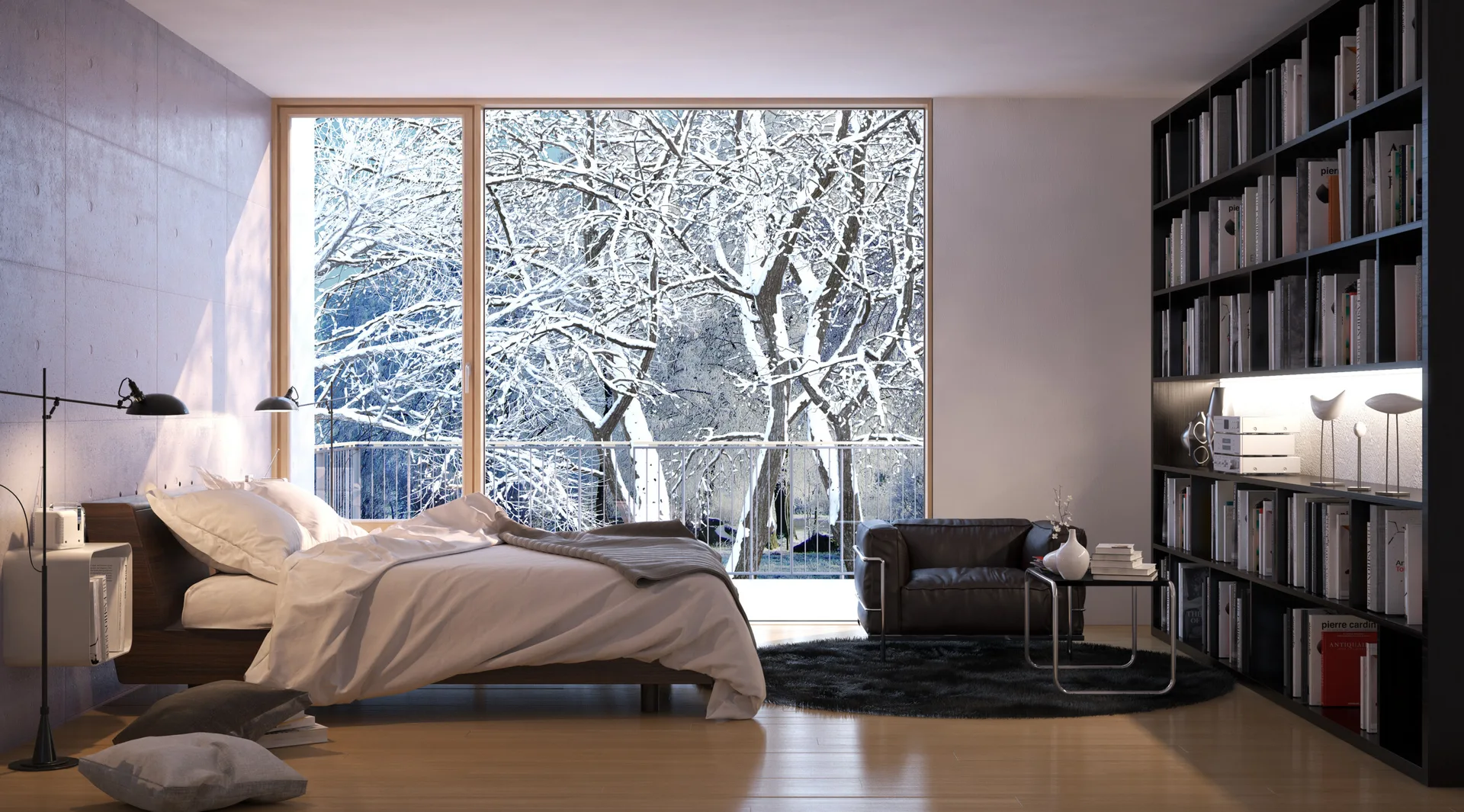 A minimalist bedroom featuring a low bed with white linens, a dark leather armchair, and a tall black bookcase next to a large window overlooking snowy trees.