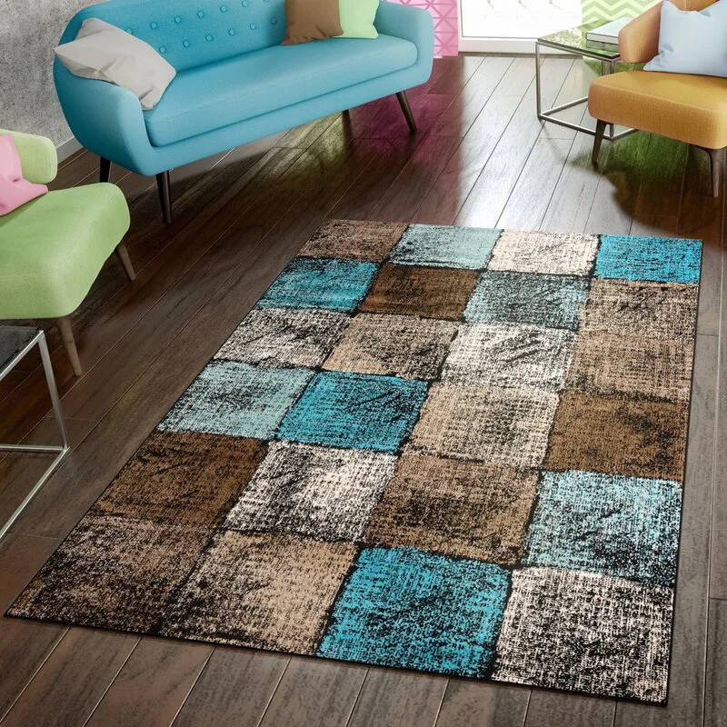 A distressed checkered area rug with blue and brown squares lies on a dark wood floor near a blue sofa and colorful accent chairs.