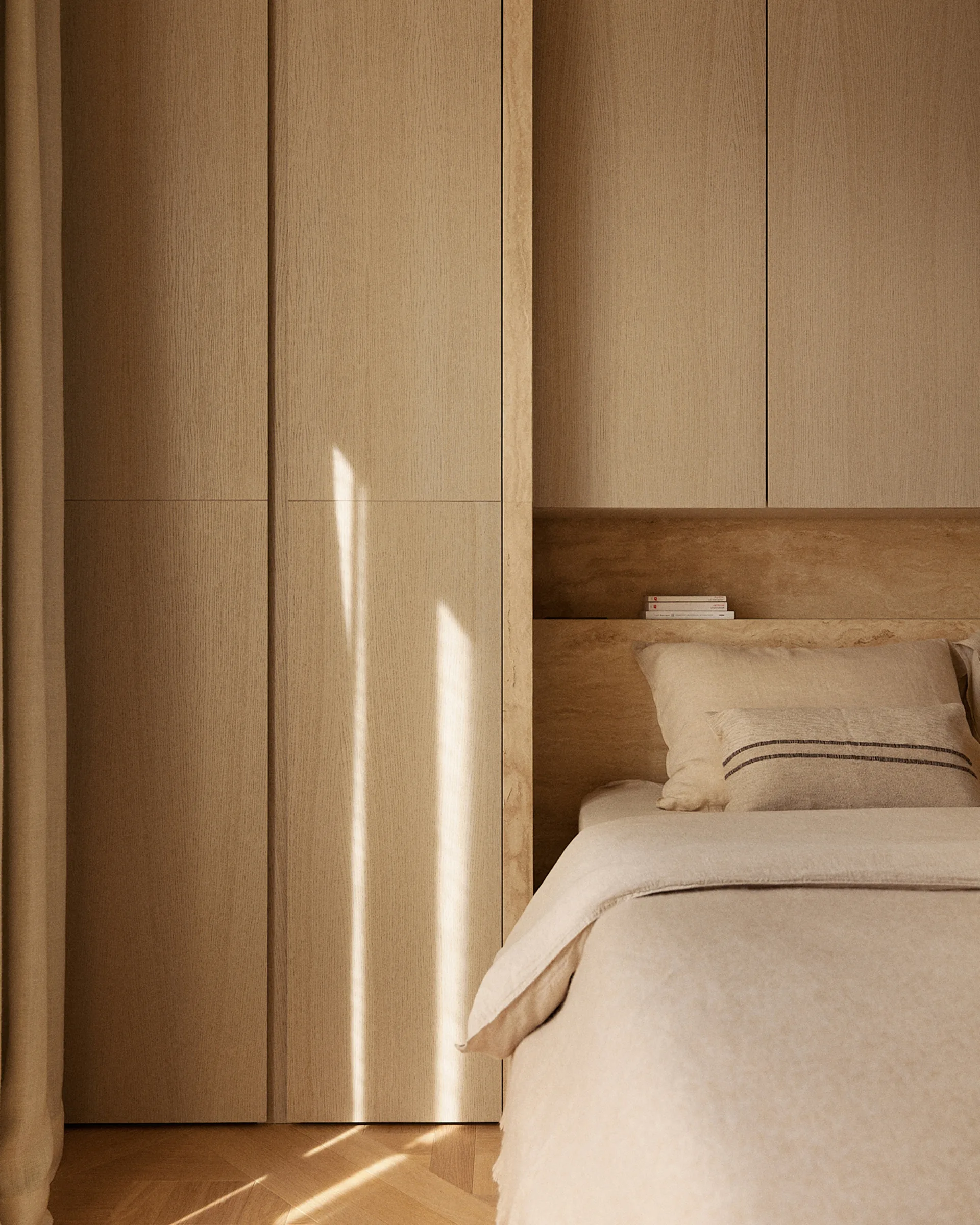 Minimalist bedroom featuring light wood built-in wardrobes, a recessed stone ledge behind the bed, and neutral linen bedding.