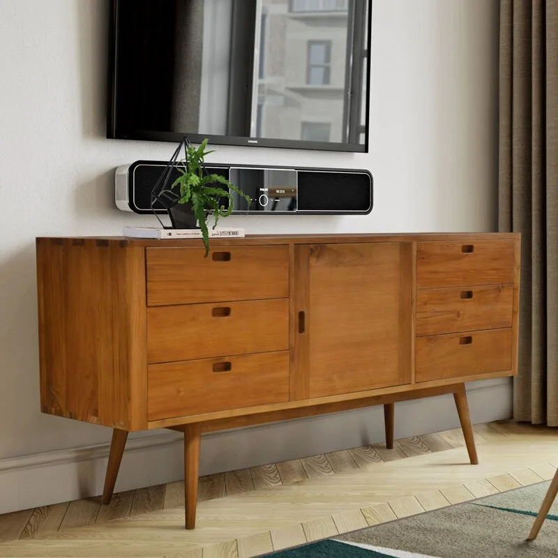 A mid-century wooden sideboard with tapered legs stands on a herringbone parquet floor beneath a wall-mounted television and a black soundbar.