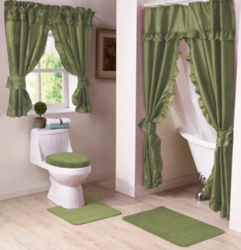 A traditional bathroom displays a matching set of sage green ruffled curtains, toilet lid cover, and plush green bath mats.