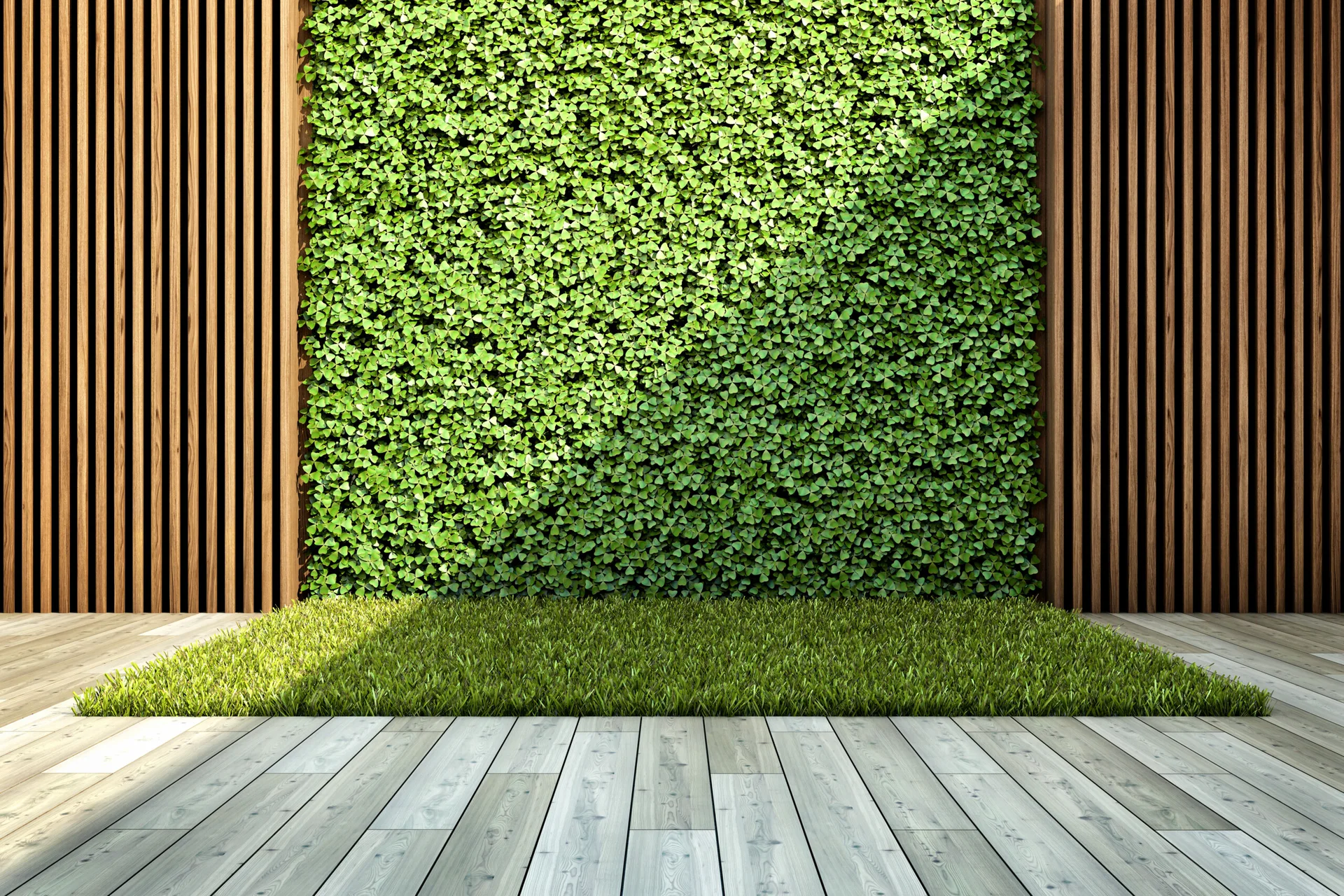 A vertical green plant wall flanked by dark wood slats stands above a light wood plank deck featuring a rectangular grass inlay.