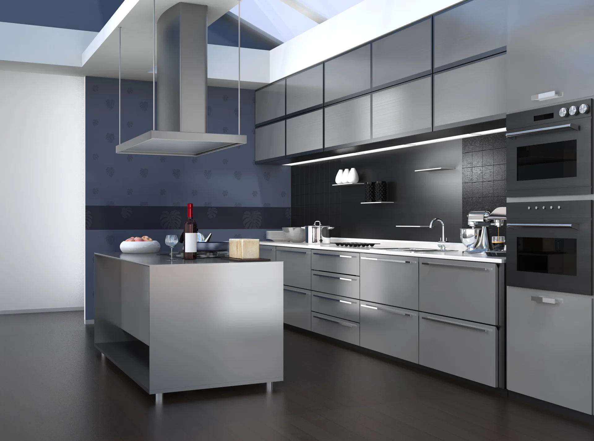 A modern kitchen featuring stainless steel cabinetry, a matching island, a dark tiled backsplash, and natural light from a large ceiling skylight.