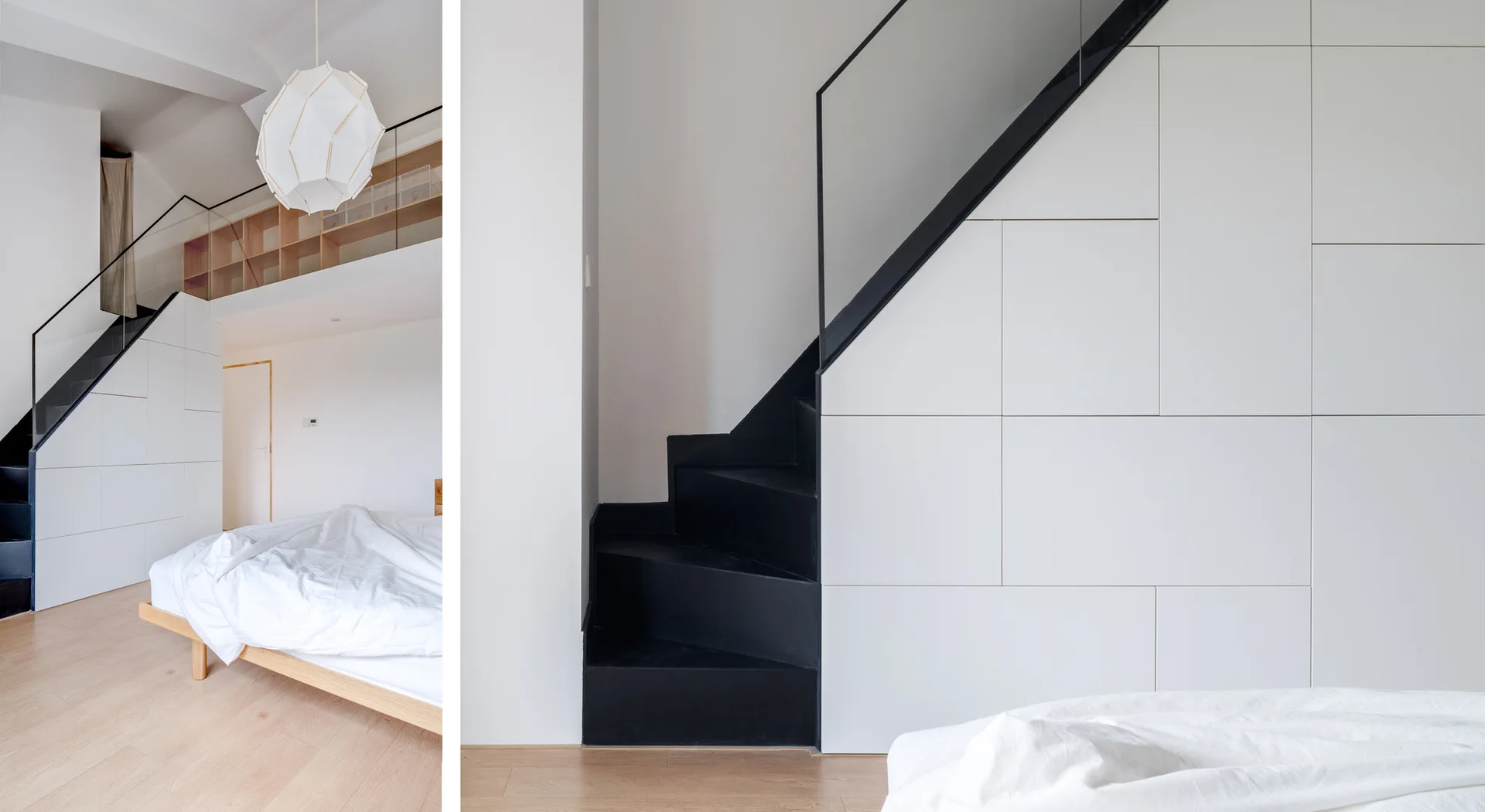 A modern loft bedroom features a minimalist low wood bed and a matte black staircase integrated with white handleless under-stair storage cabinets.