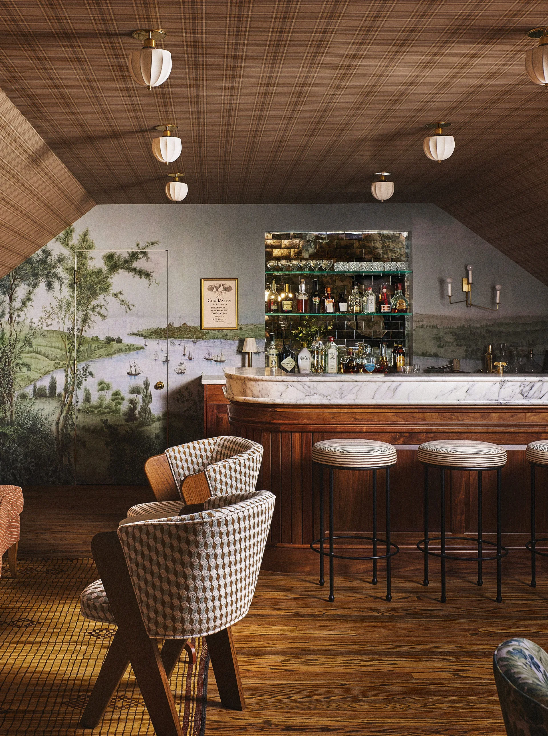 A home bar features a curved wood counter with a white marble top, striped stools, a landscape mural wall, and a plaid-patterned ceiling.